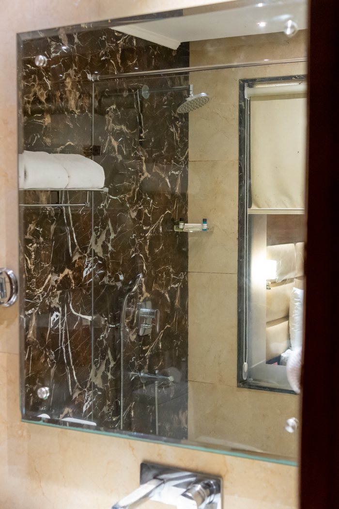 An executive bathroom, dark marble and the glass shower
