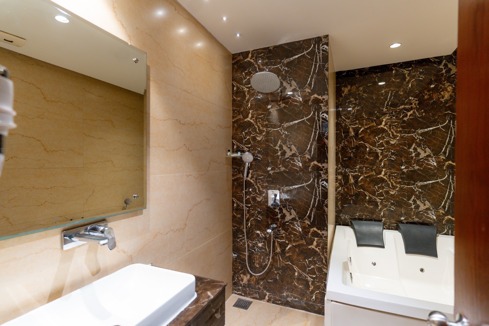 Suite: The bathroom, the rain shower in dark marble beside the tub