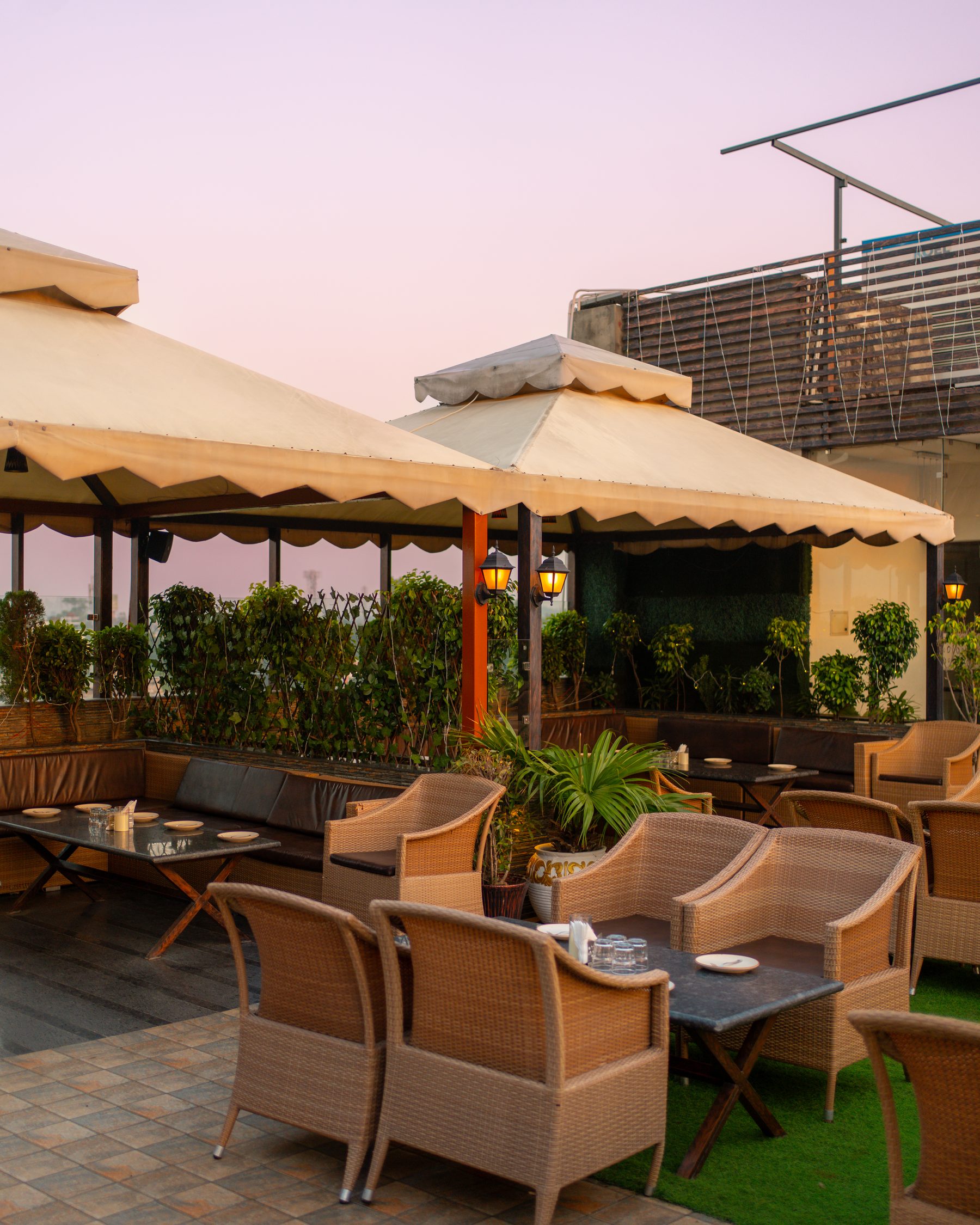The terrace under its umbrellas, the evening sky behind